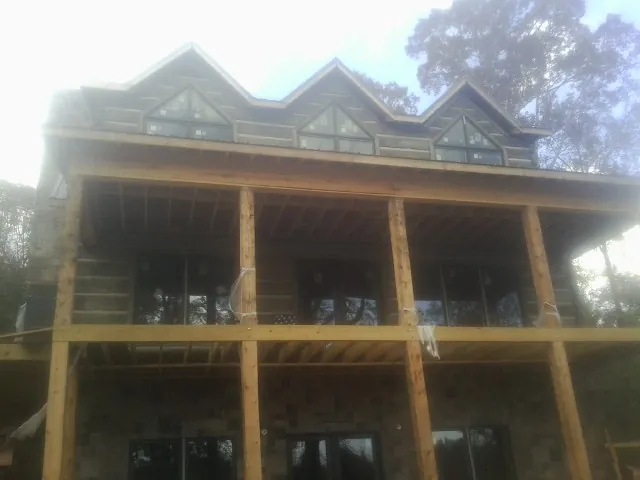 Dormers and porch framing on a large log home under construction — Roof Coating work by our crew in Morgan City