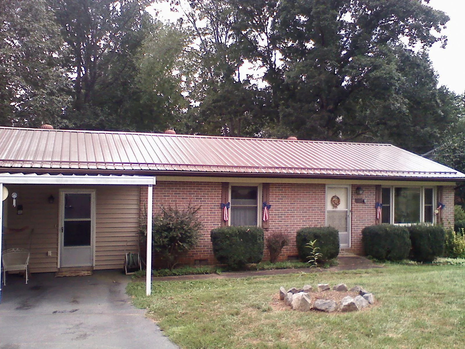 Bronze metal roof and carport on a brick ranch home — Roof Repair work by our crew in Morgan City